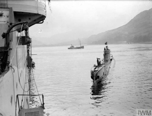 HM Submarine TUNA, with her Jolly Roger flying as she approaches the depot ship HMS FORTH.