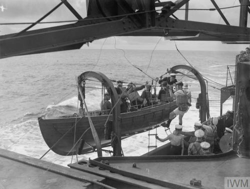 Imperial War Museum photo, 1941, of an RN whaler lowering lifeboat to ferry men and goods ashore.